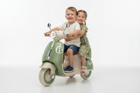 Children's Vespa motor bike toy with green and beige design on a white background qatar