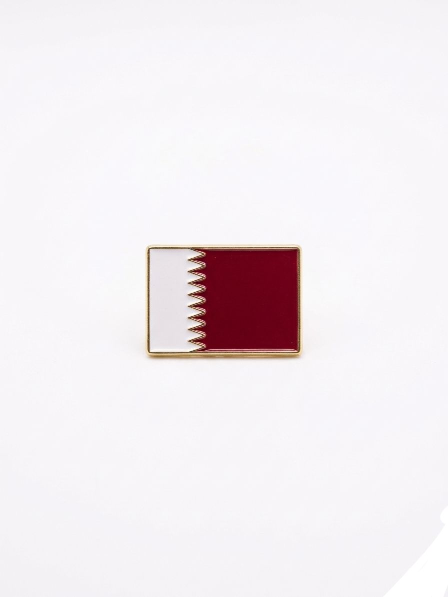 Flag pin of Qatar on a white background