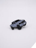 Gray truck-shaped enamel pin on a light gray background QATAR PRICE